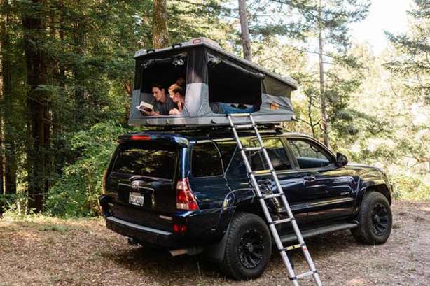 Couple Reading Book in Vehicle Roof Top Tent